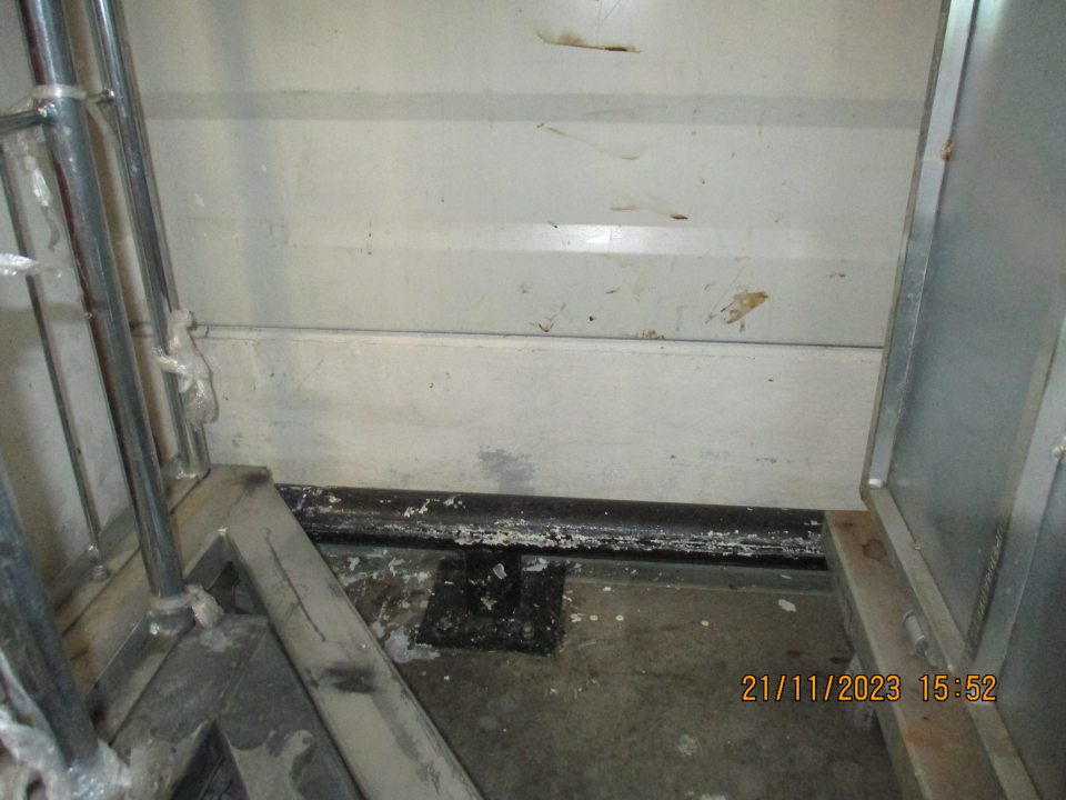 V časti vyhradeným a označeným - Prepravky ovocie - zelenina, prepravky mäso, prepravky DC, prepravky dodávateľ, znečistená stena neznámou hnedou tekutinou. A v spodnej časti značne znečistená kovová zábrana a podlaha bielou farbou. 