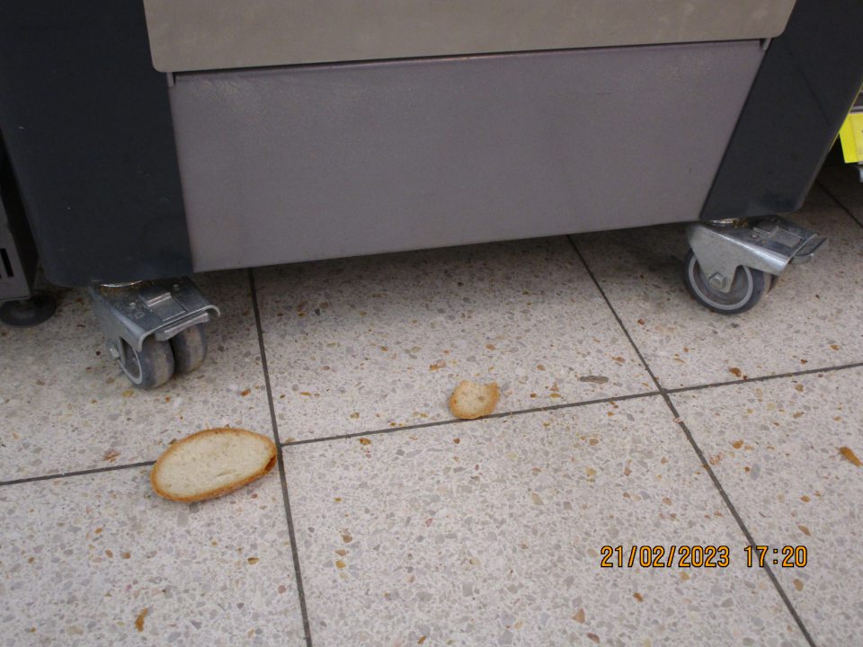 predajná plocha: - na predajnej ploce v časti pečiva pred strojom na krájanie chleba na podlahe a vo vrchnej časti stroja znečistenie zvyškami chleba