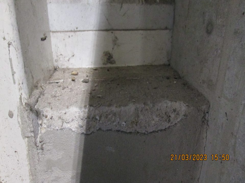 Pri príjmovej rampe v zázemí predajne na múriku nános prachu, kamienkov, nečistôt a pavučín.