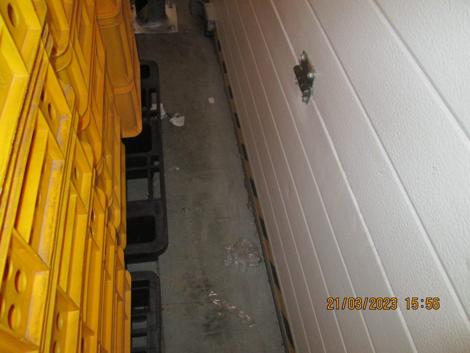 Za prázdnymi prepravkami určenými na pečivo na podlahe  nájdené útržky fólie a kúsky štítkov.