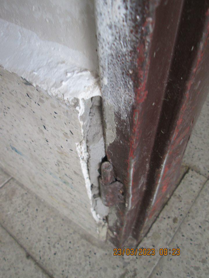 V zázemí prevádzky pri zadnom vstupe poškodený na dvoch miestach v spodnej časti keramický obklad steny.