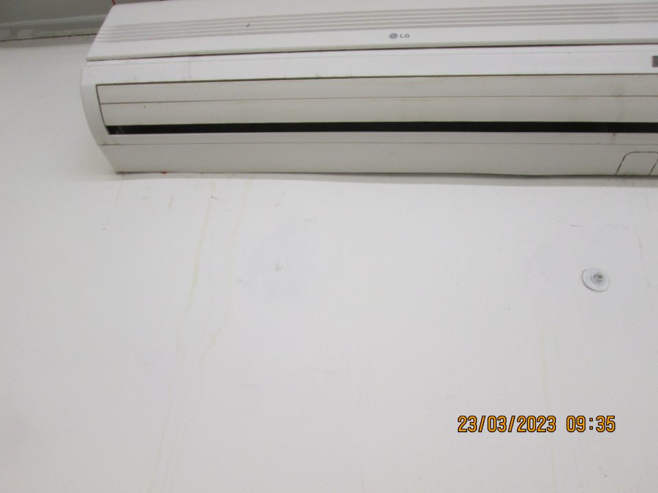 Zatečená stena pod klimatizačnou jednotkou umiestnenou pri vstupe do prevádzky.