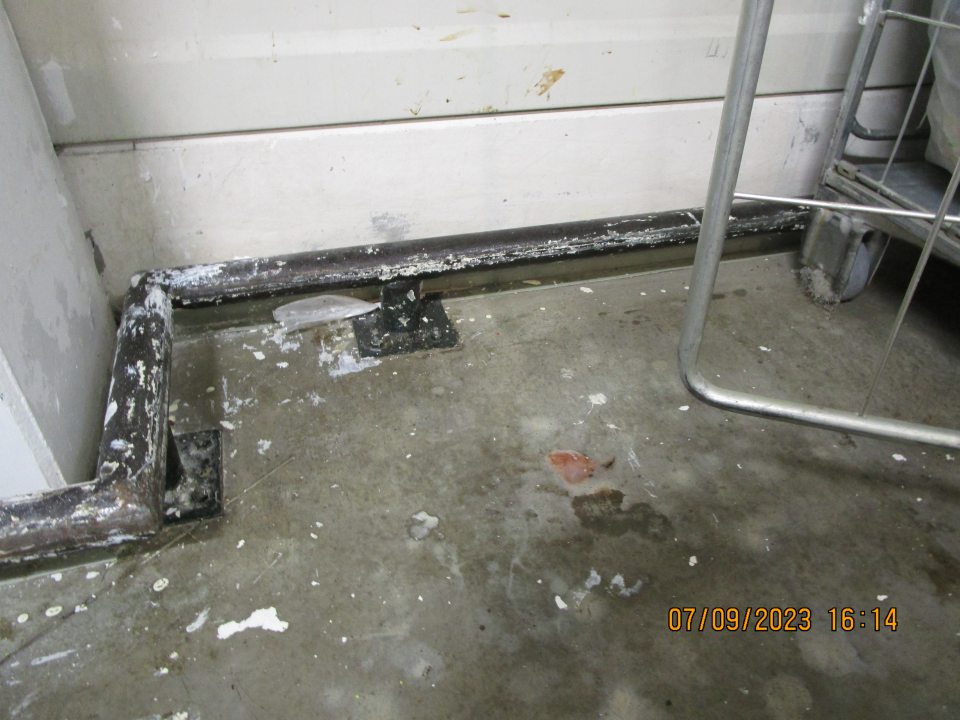  vpravo od mraziaceho boxu okolo kovového rámu hrubý nános špiny a nečistôt