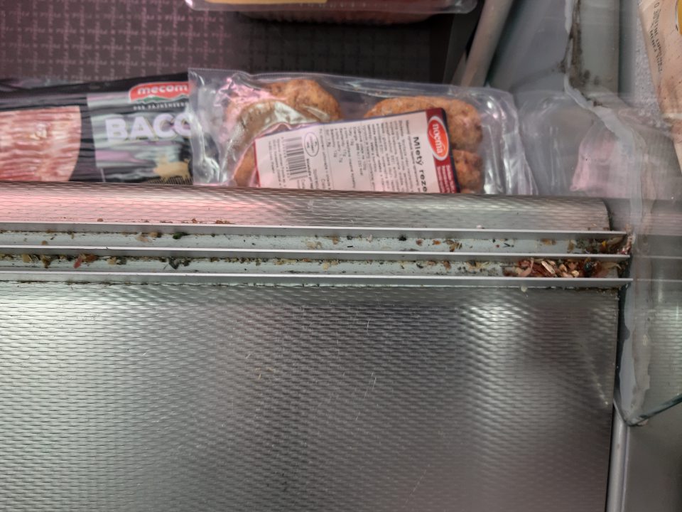  Znečistená chladiarenská vitrína pre mäsové výrobky v časti líšt posuvných dvierok.