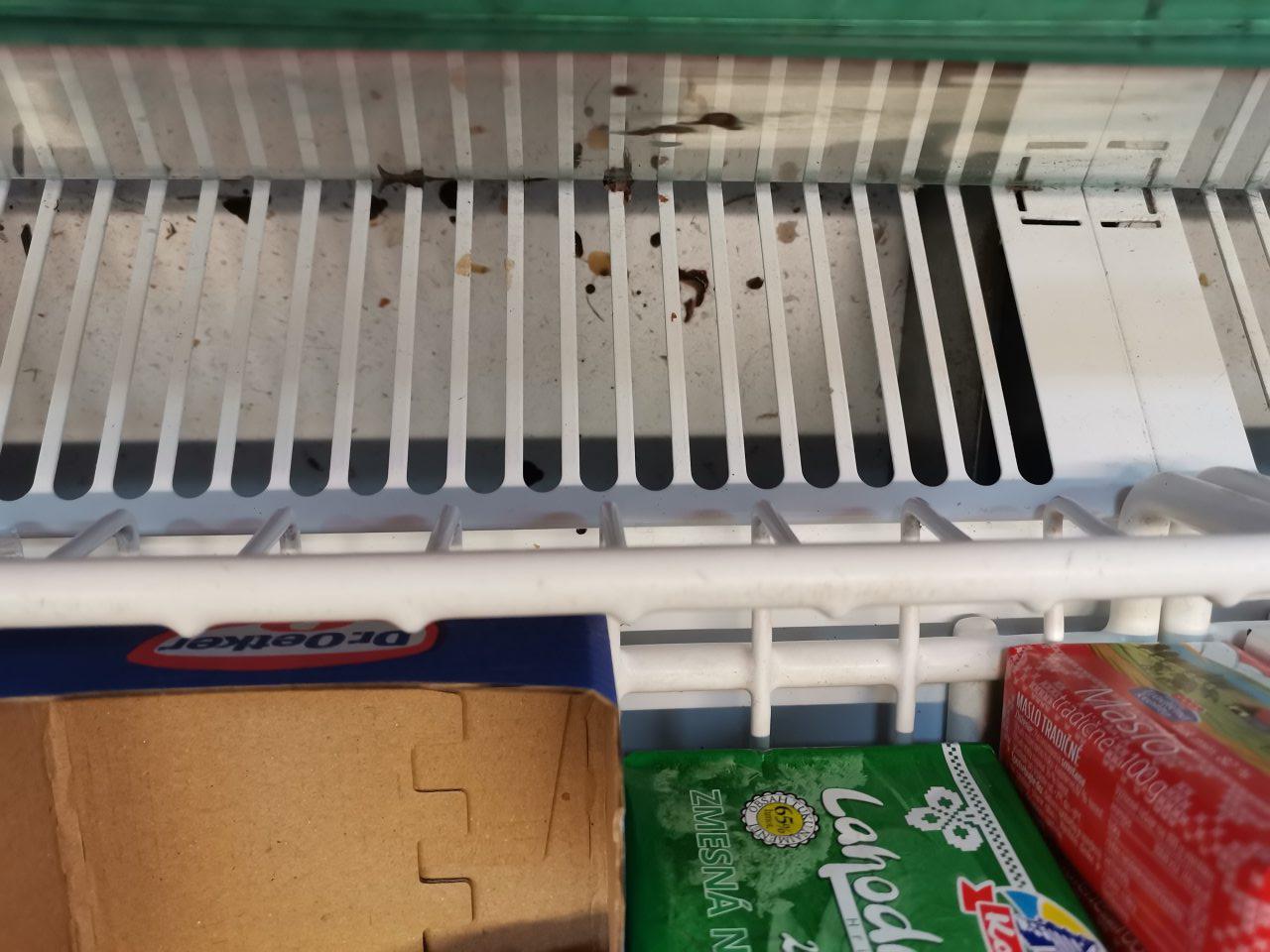 Ložná plocha chladiarenskej vitríny na predajnej ploche určenej na uchovávanie mliečnych výrobkov bola v časti pod mriežkami znečistená hrubou nečistotou - zvyškami zasušených potravín, prachom.