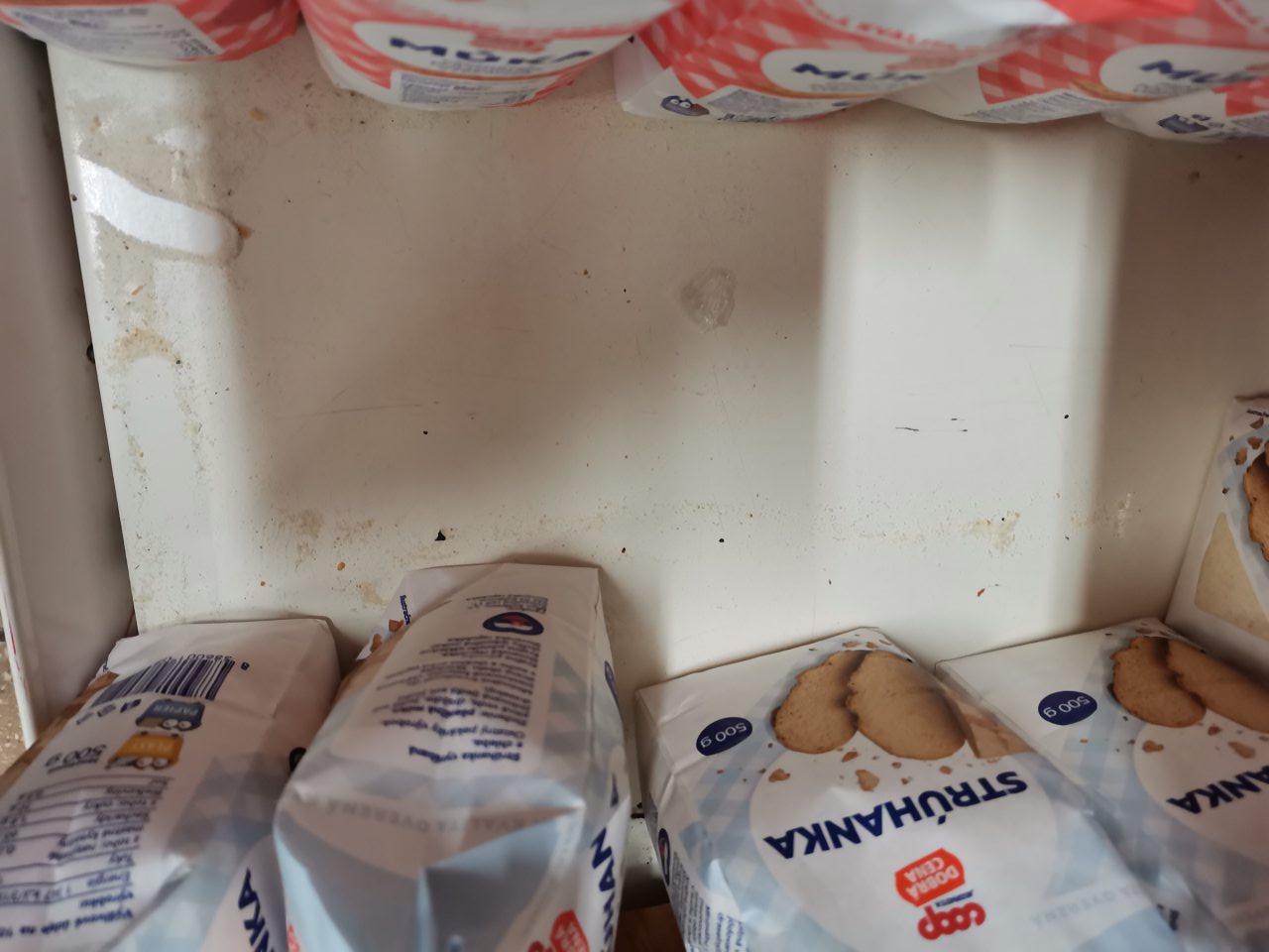 Regál na predajnej ploche určený na uchovávanie strúhanky a múky je znečistený hrubou vrstvou prachu a zvyškami potravín - múkou.