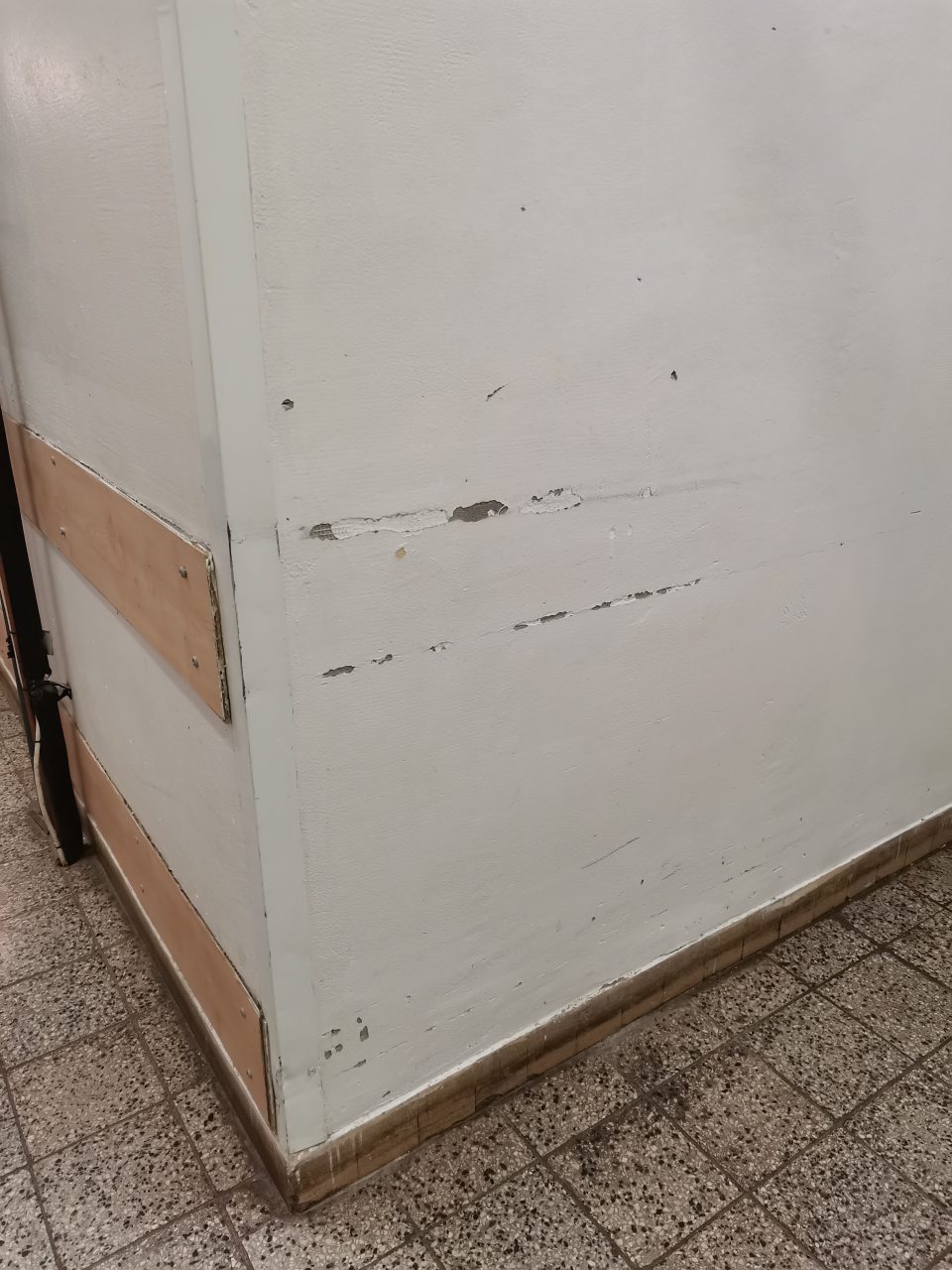 - Stena v manipulačnej chodbe je miestami poškodená, omietka opadaná