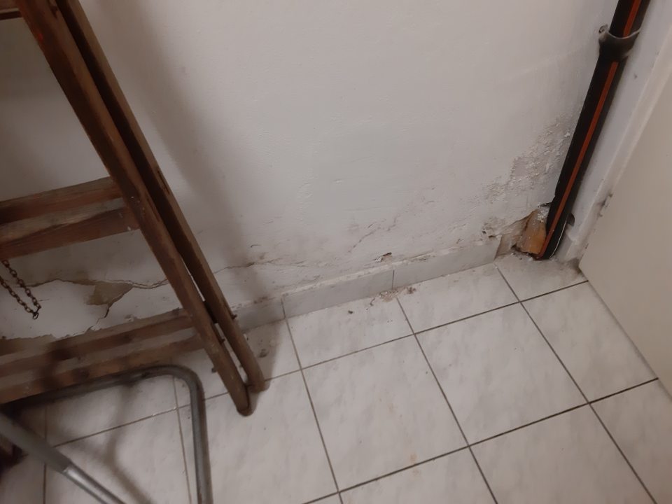 Stena v manipulačnom priestore pri chladiacom boxe  má poškodenú , opadávajúcu omietku. Podlaha v jej blízkosti je znečistená hrubou nečistotou a zvyškami opadanej omietky.