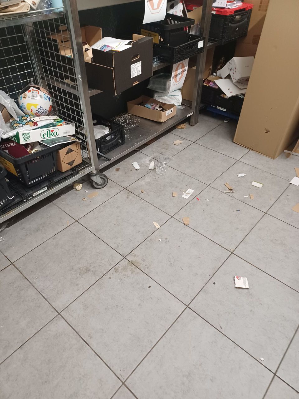 Priestor s lisom - znečistená podlaha s nánosom zvyškov obalov, znečistené police regálu s odpismi.