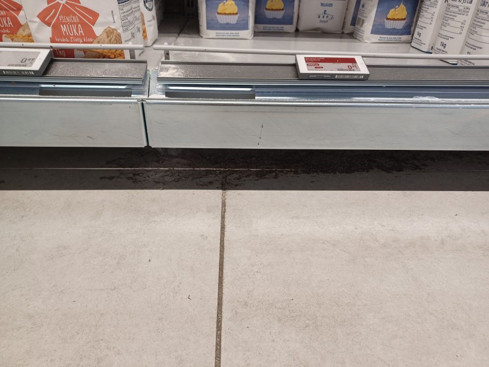 Nálepy na podlahe pod regálom s múkou a cukrom.
