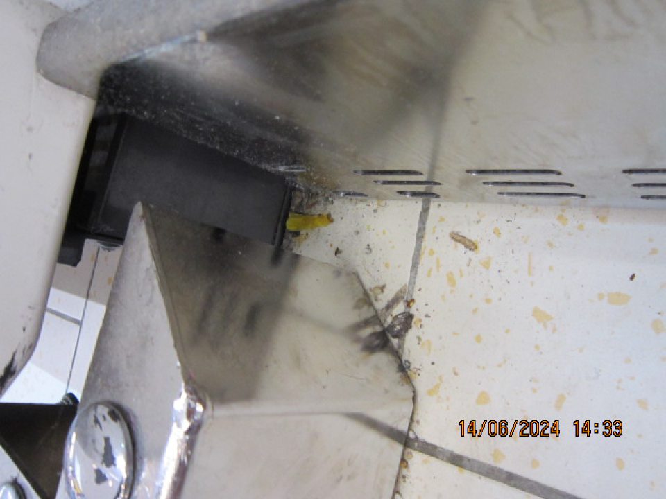 Predajná plocha: Znečistená podlaha pri chladiacich boxoch s precenenými potravinami, znečistenie prachom, napadanými nečistotami.