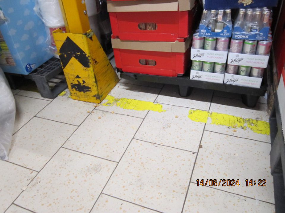 Znečistená podlaha v sklade v časti, kde boli umiestnené suché potraviny - podlaha znečistená zvyškami potravín (cereálie), prachom