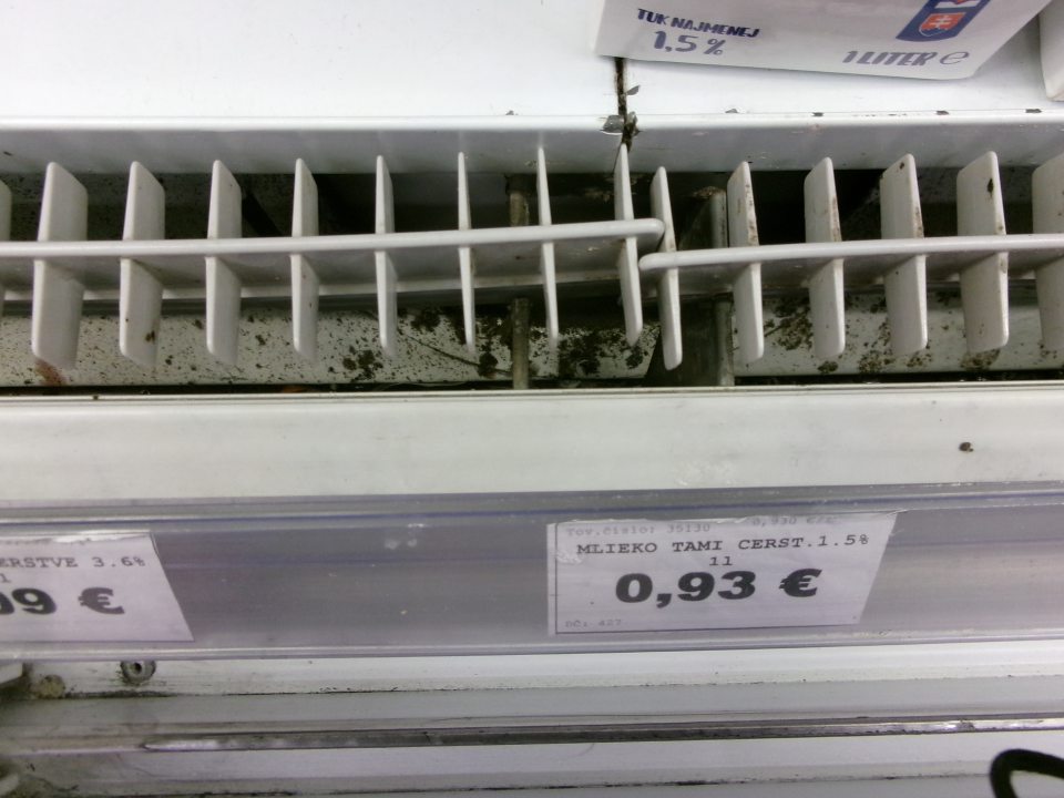 Zistený znečistený priestor pod kovovou mriežkou v chladiarenskom zariadení s uchovávanými mliečnymi výrobkami. 