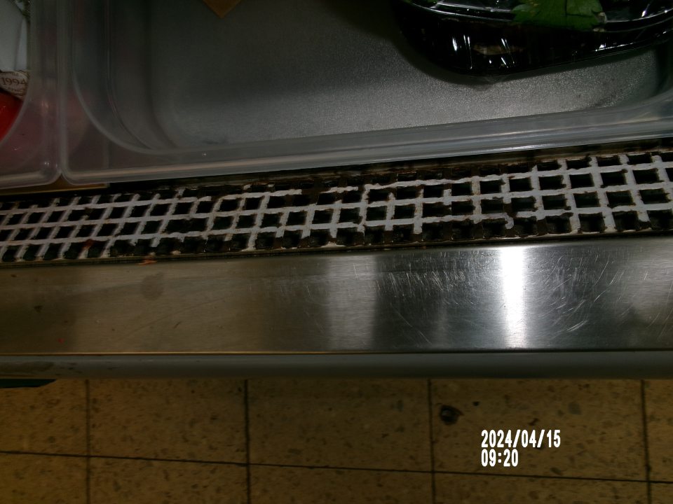 Skorordovaná mriežka chladiarenského zariadenia s uchovávanou čerstvou zeleninou. 