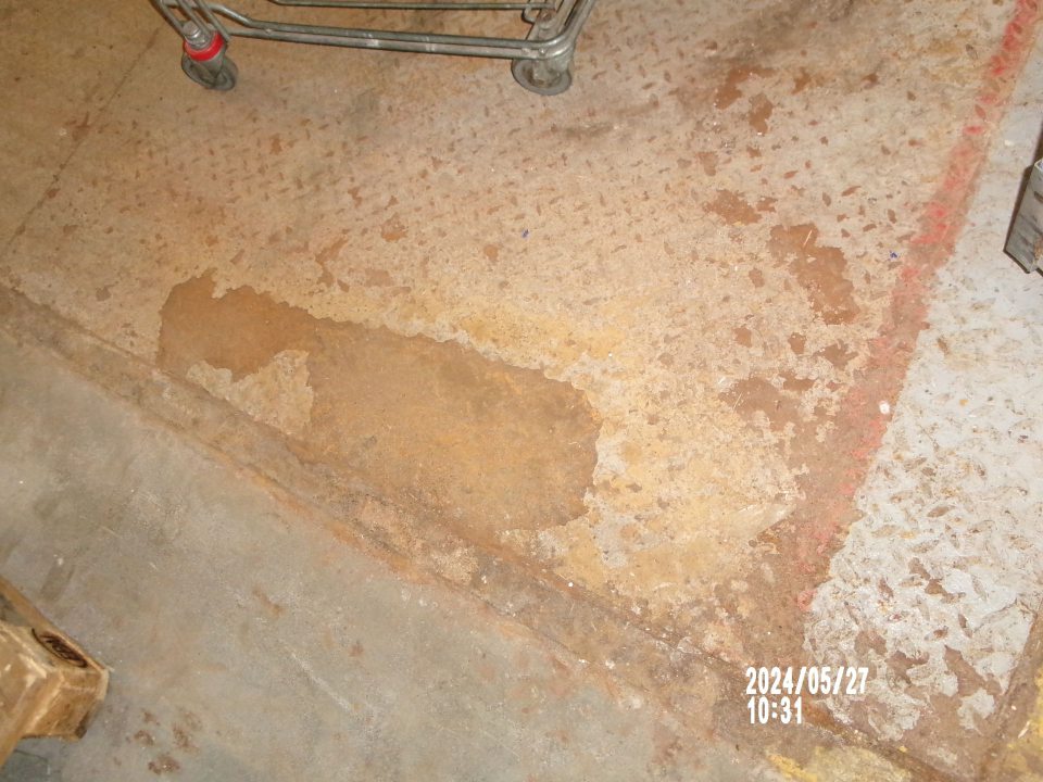 Zistený poškodený, opotrebovaný náter podlahy na príjmovej rampe. 