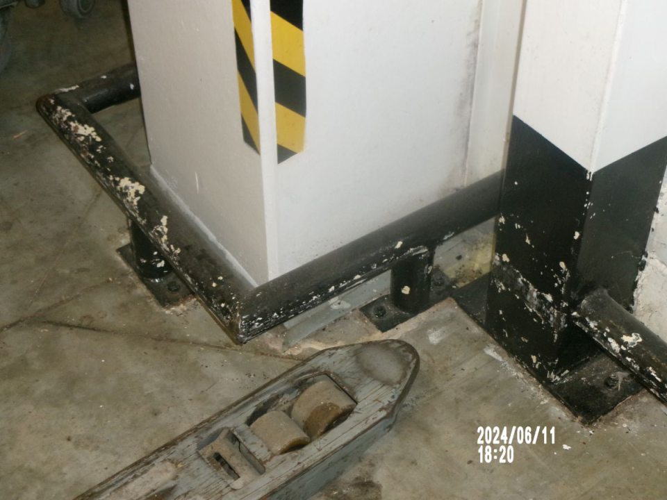 Poškodený náter kovových zábran v sklade.