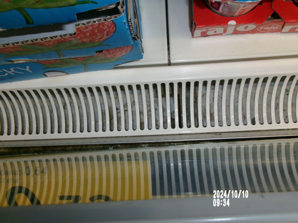 Znečistené chladiarenské zariadenia s uchovávanými mliečnymi výrobkami, pod kovovou mriežkou, a to zvyškami rozliatych potravín staršieho dáta, ako aj zhlukmi prachu. 