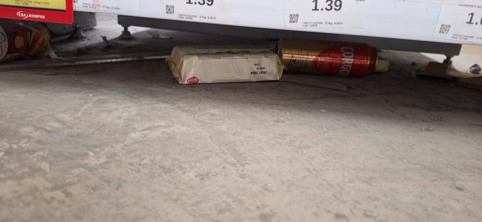 Znečistená podlaha pod regálmi s popadanými potravinami (DMT spadnutého výrobku 20.1.2024, kontrola vykonaná 17.9.2024, priestor nečistený min. 8 mesiacov).