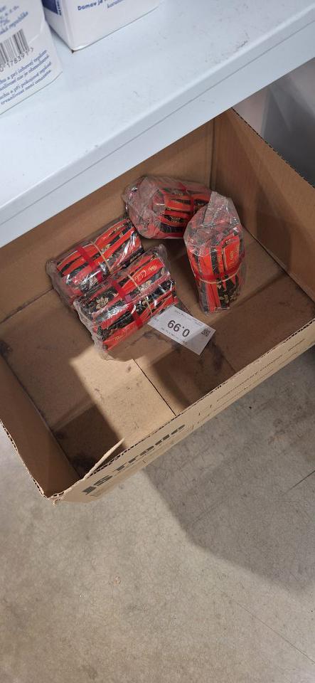 Chuchvalce prachu v krabici s baleným cukrom vystaveným na predajnej ploche.