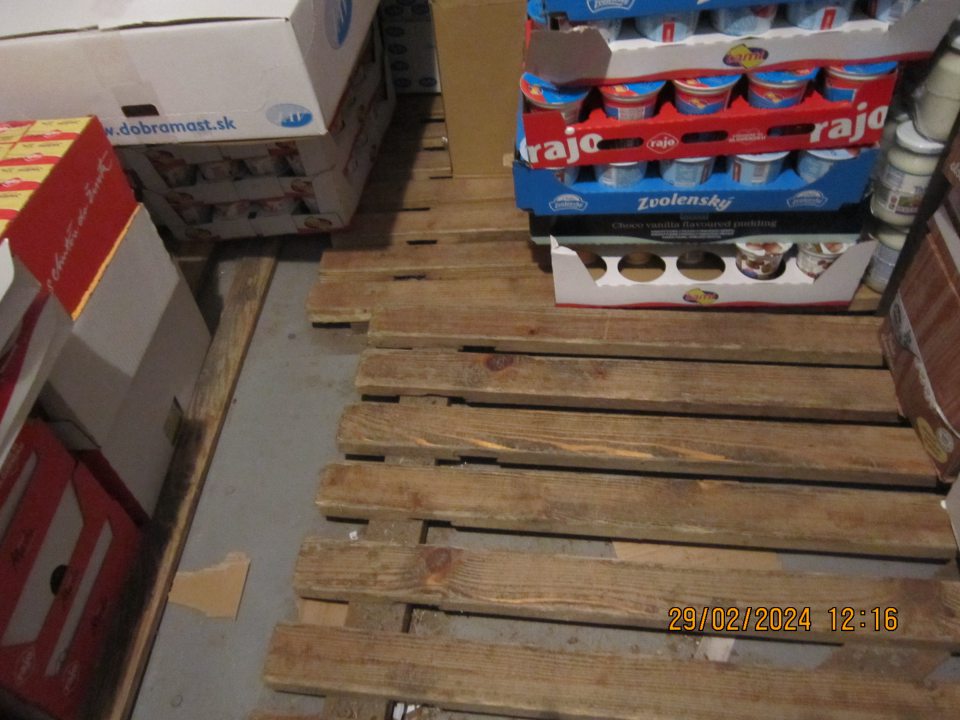 Prítomnosť mechanických  nečistôt a zbytkov obalových materiálov na podlahe pod paletami v  chladiacom zariadení v skladovacích priestoroch prevádzky.