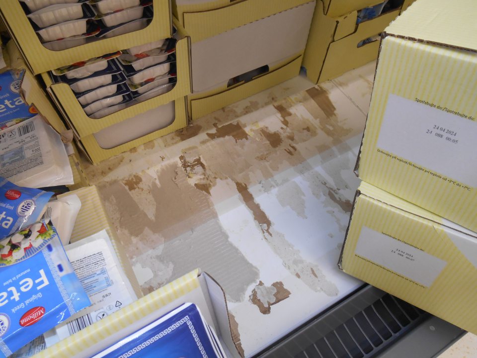 V predajnej časti prevádzky znečistený regál v chladiacom zariadení na uchovávanie mliečnych výrobkov – prilepené kúsky kartónového papiera, zaschnuté nečistoty.