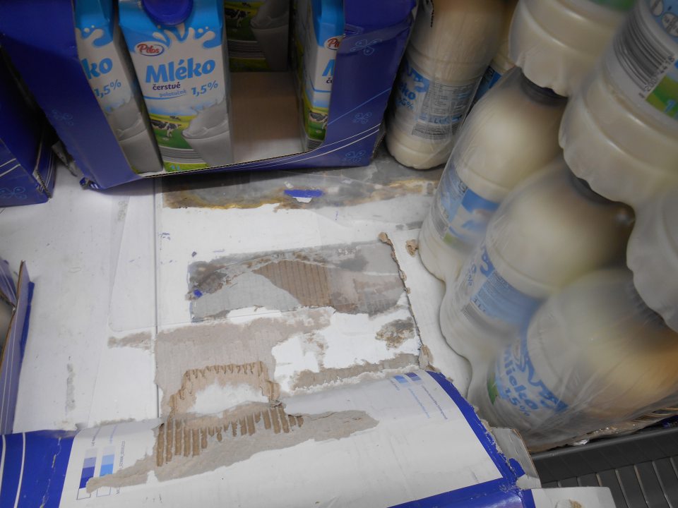 V predajnej časti prevádzky znečistený regál v chladiacom zariadení na uchovávanie mlieka a mliečnych výrobkov – prilepené kúsky kartónového papiera, zaschnuté nečistoty. 