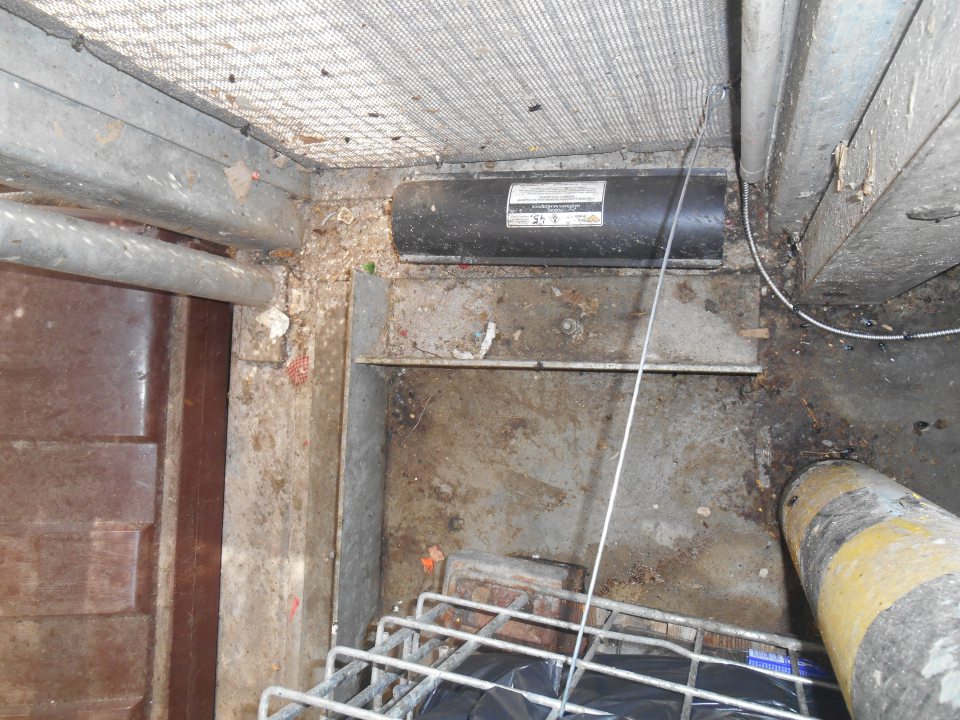 Hrubé nečistoty v priestore na rampe prevádzky pred lisovacím zariadením na zmiešaný odpad vedľa klietky s odpadom.