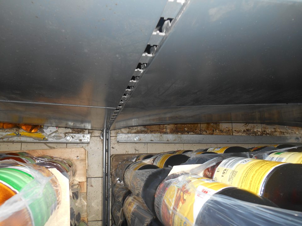 Silne znečistená podlaha za paletami s nealko nápojmi na predajnej ploche.