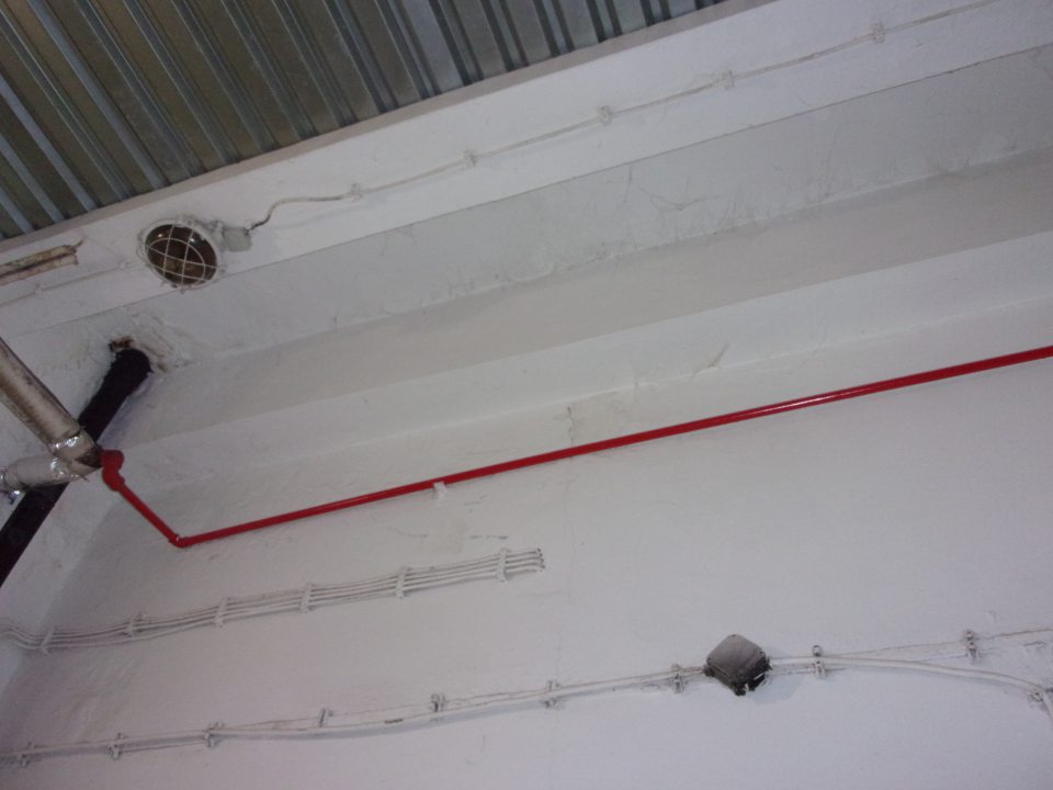 Poškodená hygienická maľba steny a stropu a prítomnosť pavučín na viacerých miestach v priestore určenom na skladovanie múky.