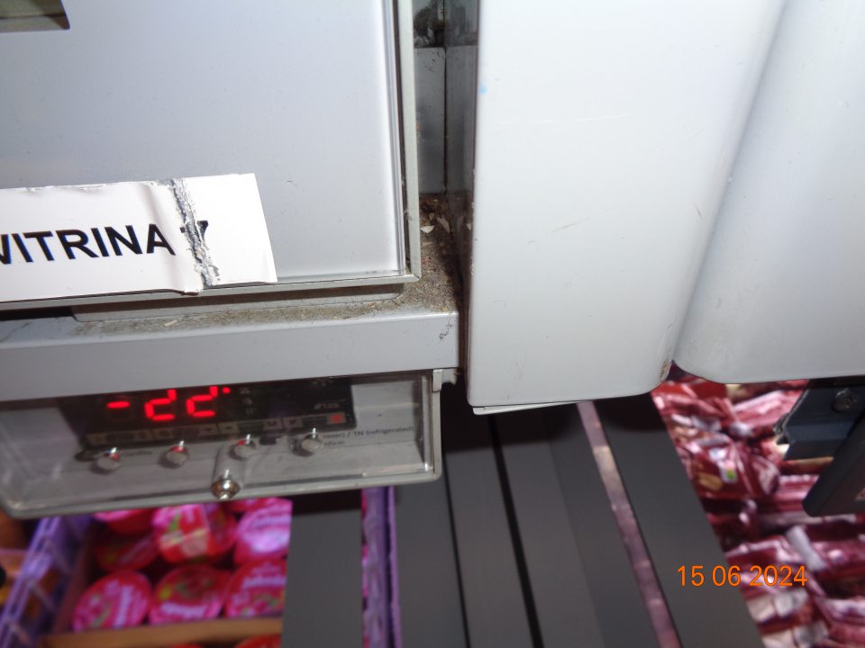 Znečistené plochy medzi otváracími dvierkami v mraziacich vitrínach na uchovávanie hlbokozmrazených potravín – vrstvou prachu, organickými nečistotami na predajnej ploche.