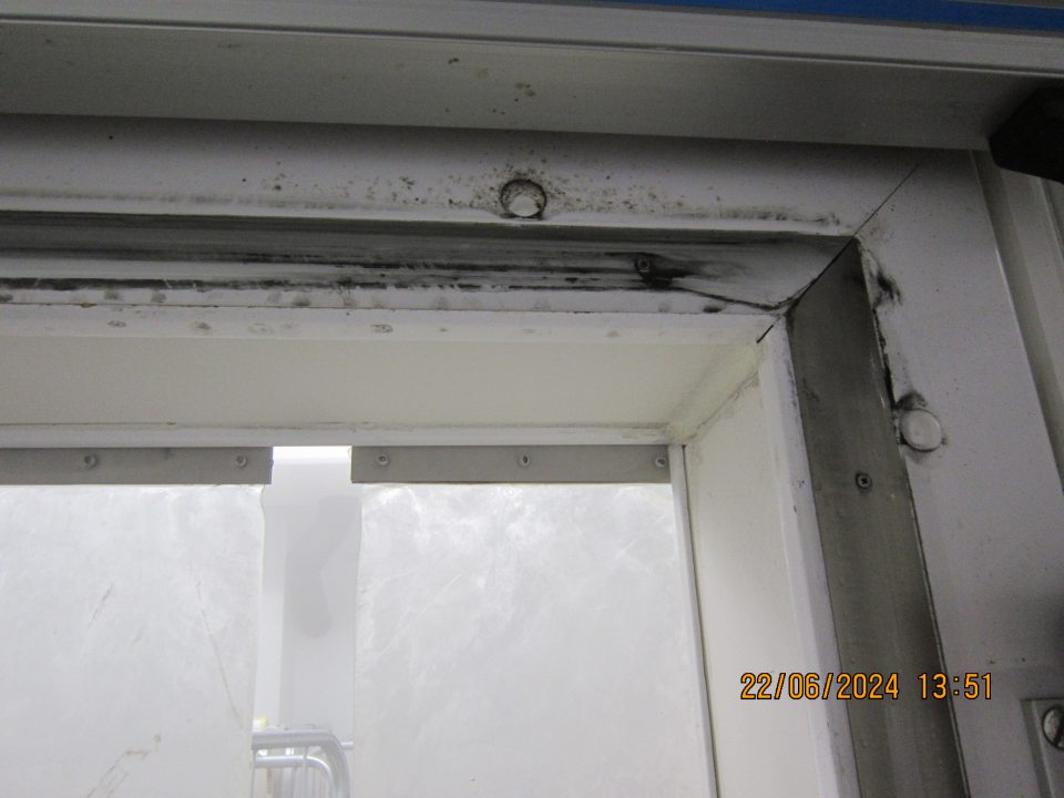 Znečistenie čiernou špinou a výskyt plesne na ráme, tesnení a v okolí zaťahovacích dverí centrálneho mraziarenského boxu v zázemí prevádzky. 