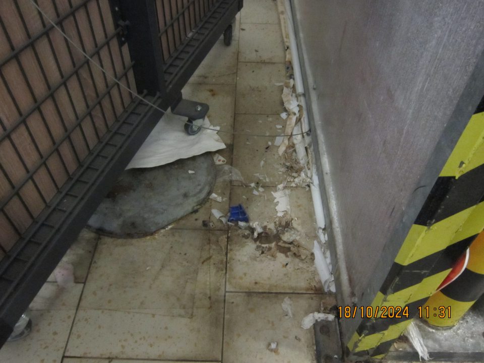 V zázemí, vo vyhradenom priestore výlevky s čistiacim strojom, medzi plastovou zástenou oddeľujúcou uvedený priestor a stojanom určeným k vykladaniu akciového tovaru podlaha  znečistená nánosmi čiernej špiny, úlomkami skla zo svietidla a kúskami kartónu.  