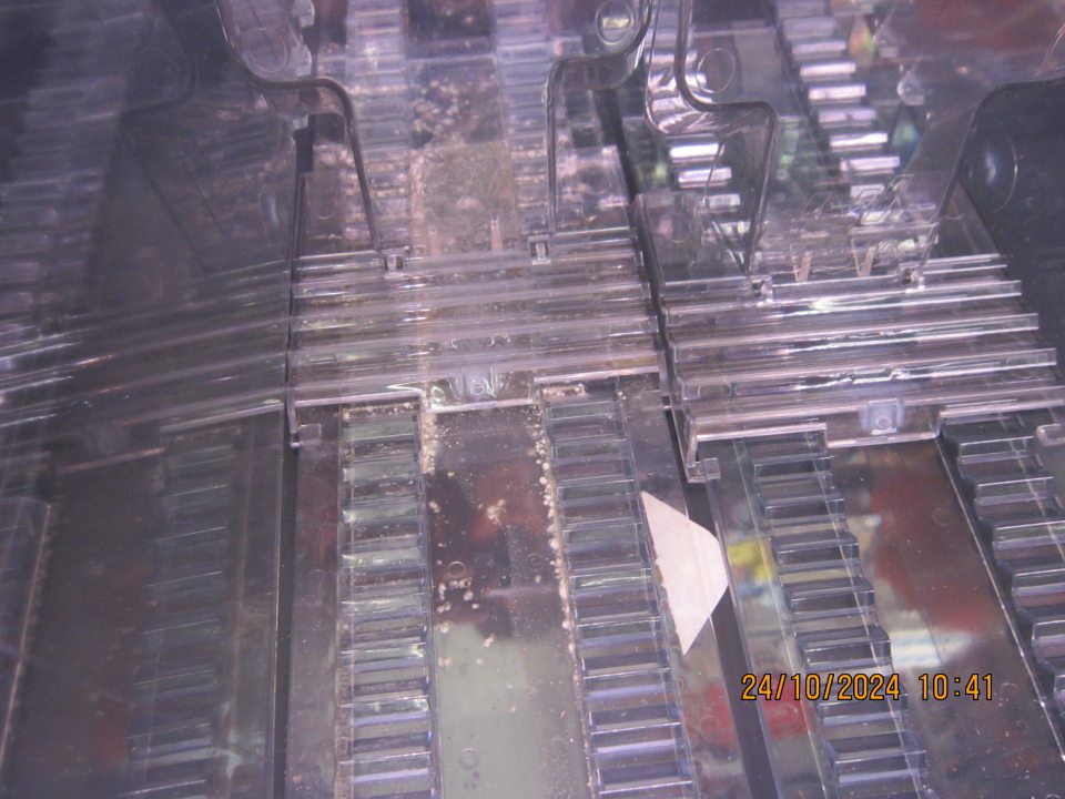 V chladiarenskej vitríne určenej na uchovávanie baleného mäsa na vrchnom regále pod plastovými lištami  silné znečistenie organickými nečistotami a zatečenou, zaschnutou tekutinou z obsahu balení.