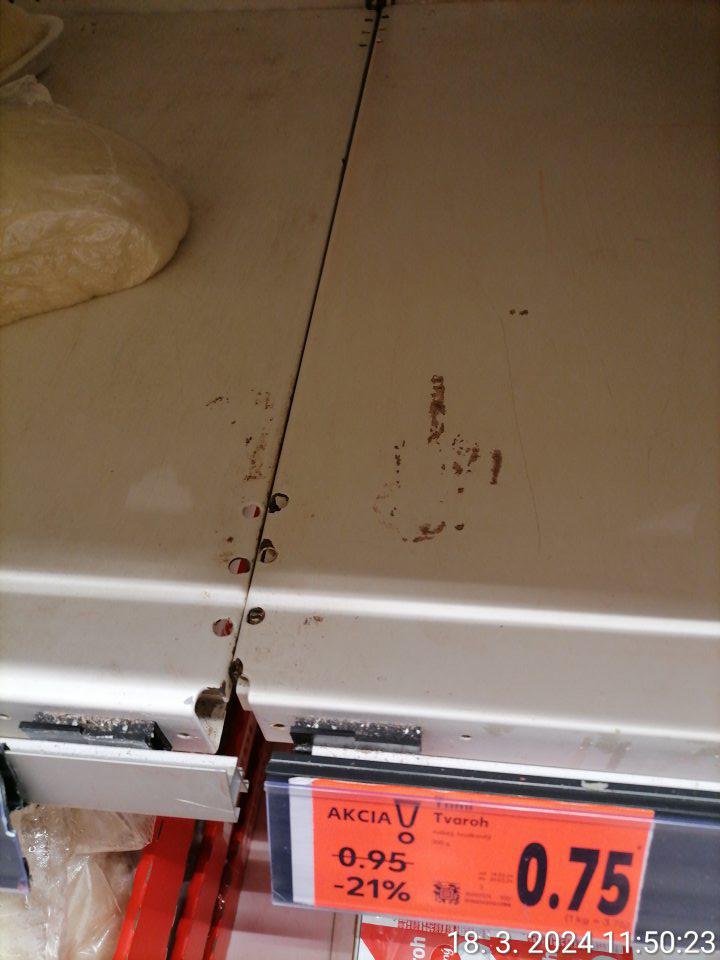 Čierne znečistenie na regáli slúžiacom na uchovávanie mliečnych výrobkov.