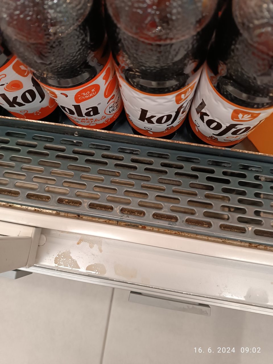 Znečistenie regálu zaschnutými obsahmi nápojov hnedej farby pri predaji ochutených nealkoholických nápojoch (kofola).