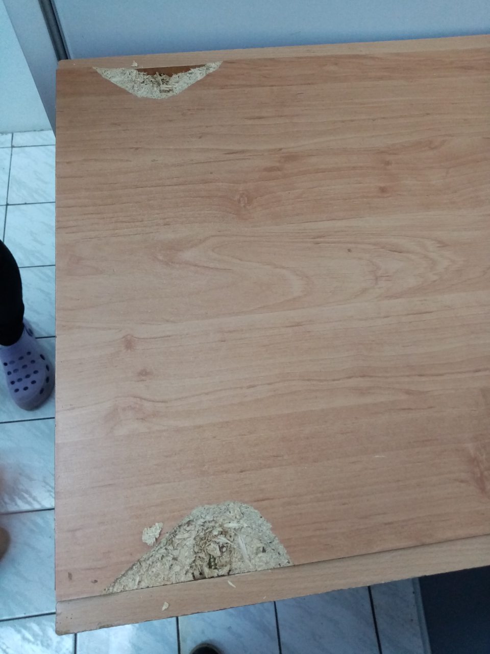 Porušená celistvosť stolíka - diery, v zázemí predajne.