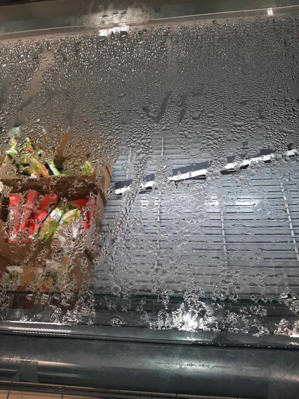 mraziaca vaňa s mrazenými krémami s hornými zatváracími dvierkami zarosenými nadmerne tak, že skondenzovaná voda steká do jej vnútra a v jej vnútornej spodnej časti namŕza