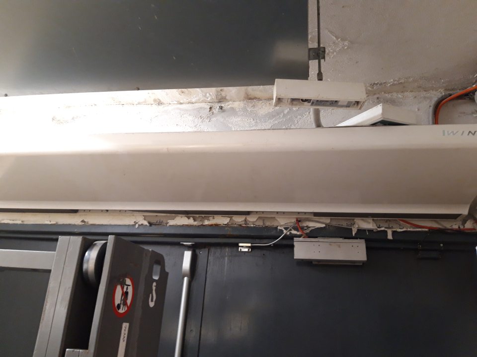 Nezabezpečená celistvosť stropu a steny nad dverami určenými na prijem tovaru.