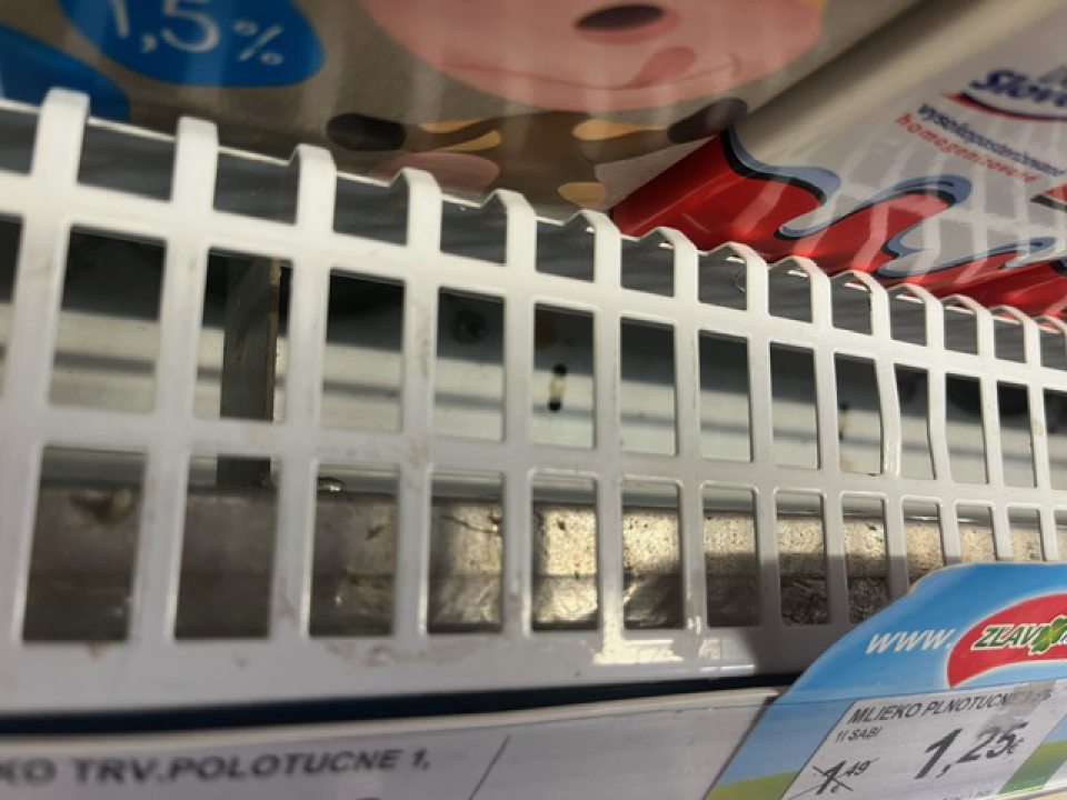 chladiaca vitrína s mliečnymi výrobkami znečistená zvyškami potravín, škvrnami hnedej farby 