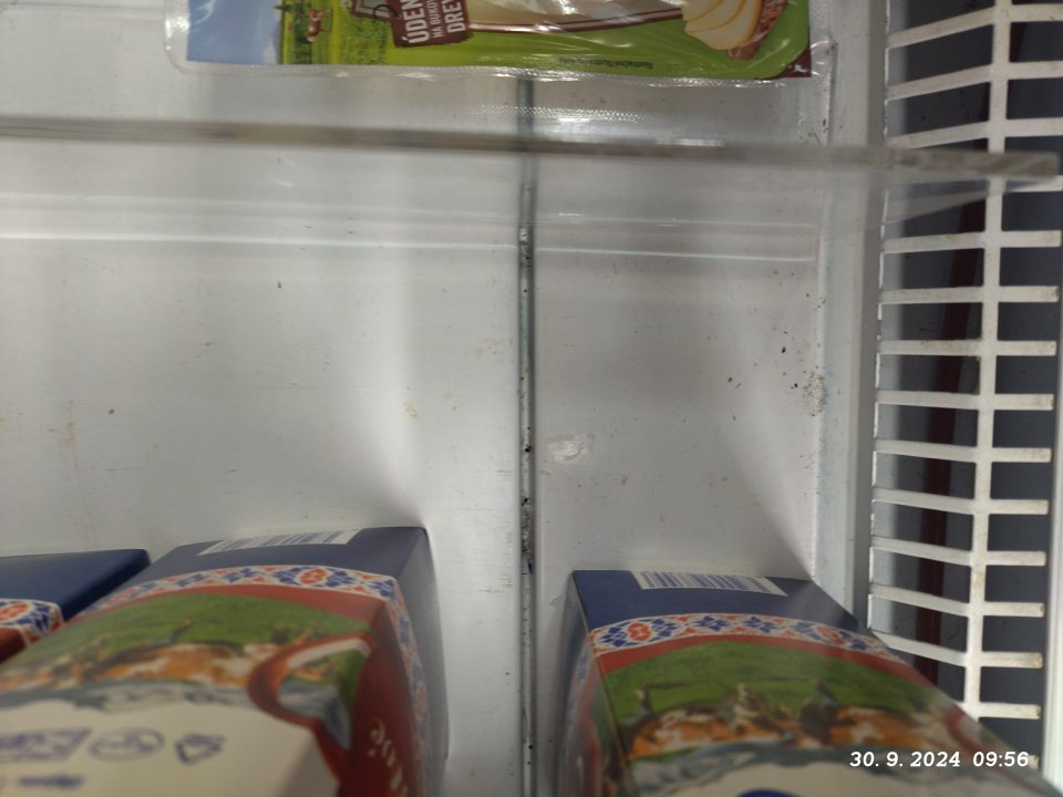 Znečistená vitrína na mliečne výrobky.