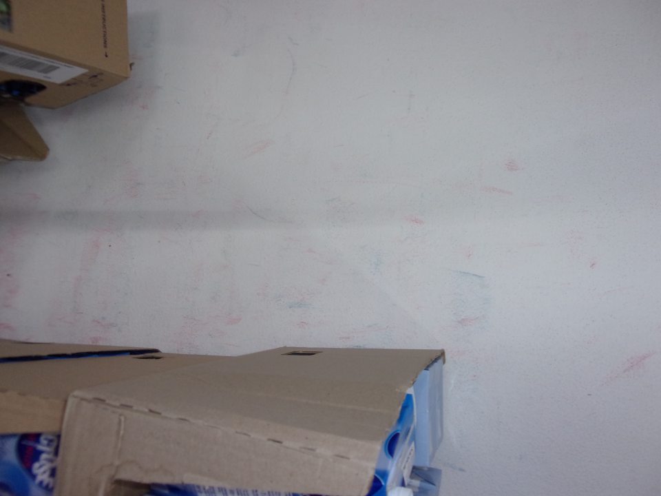 Znečistená stena pri mliečnych vitrínach na predajnej ploche.