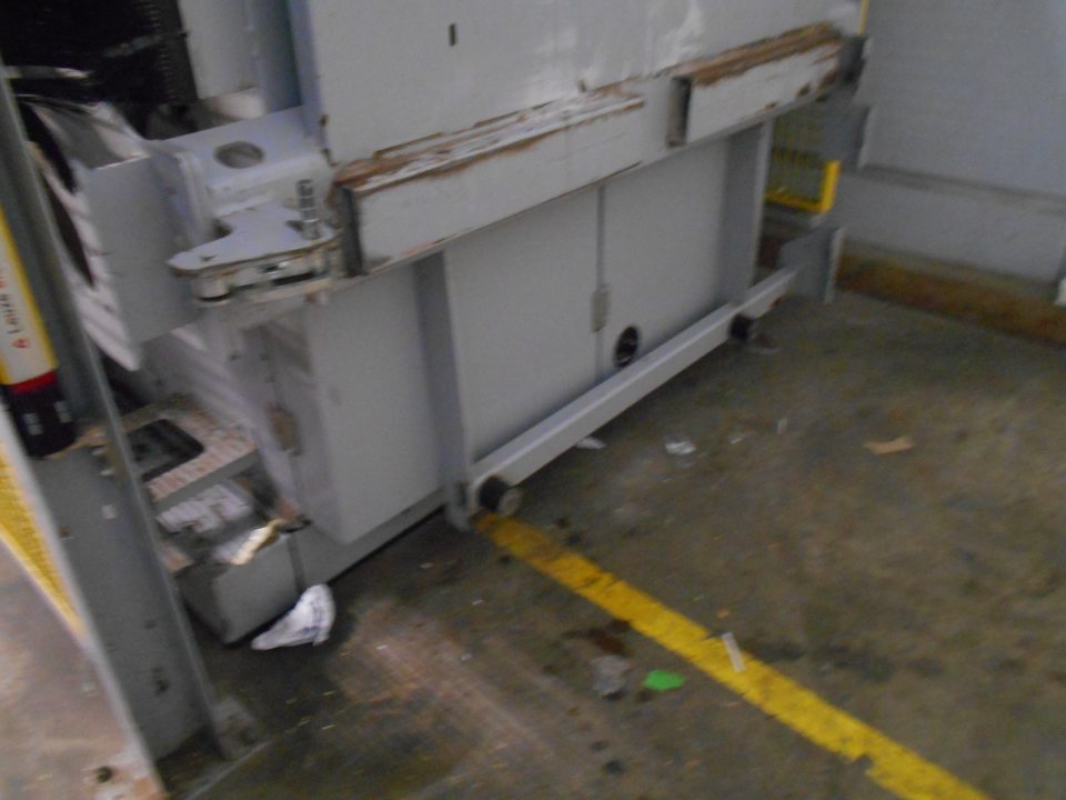 Lokálne znečistená podlaha pri prístroji na lisovanie kartónov.