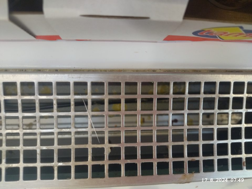 Znečistená chladiaca vitrína na mliečne výrobky.