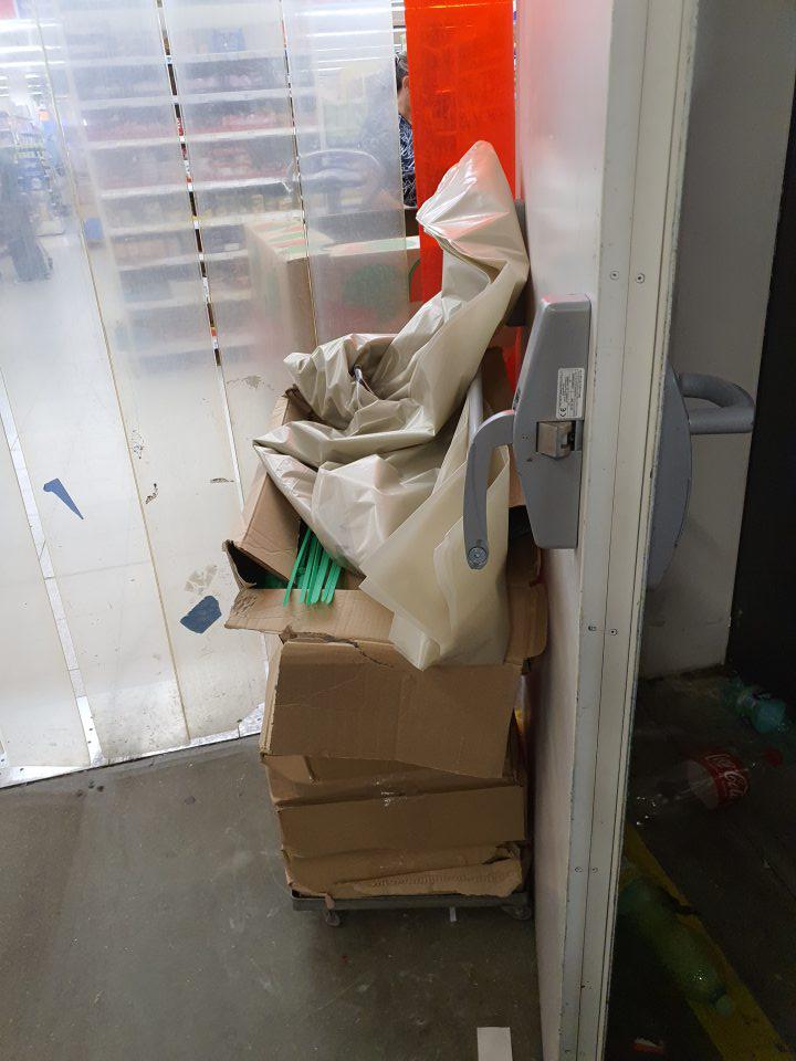 dvere oddeľujúce predajnú plochu od skladu otvorené a podopreté krabicami s plastovými vrecami na vratné fľaše