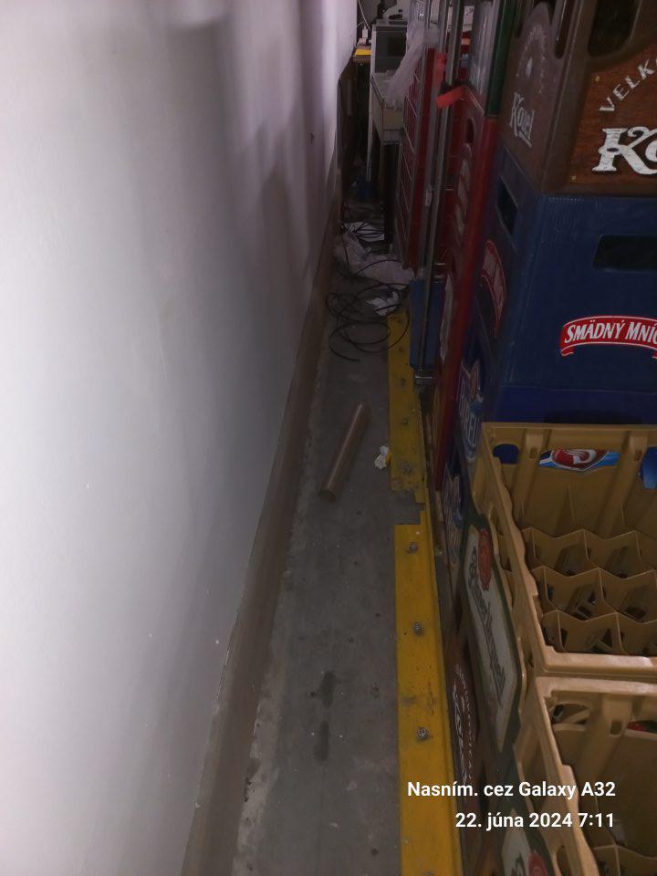 Znečistená podlaha v skladových priestoroch - zaprášená, výskyt pavučín, kúsky obalového materiálu, zvyšky paliet.