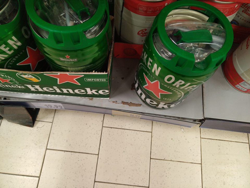 Regál s KEG sudmi s pivom s porušeným povrchovým náterom.