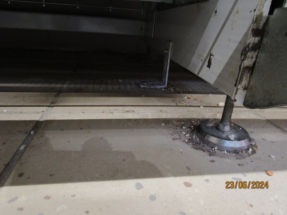 Nahromadenie nečistôt pod regálmi na predajnej ploche (prach, zvyšky surovín (múka) a obalový materiál.