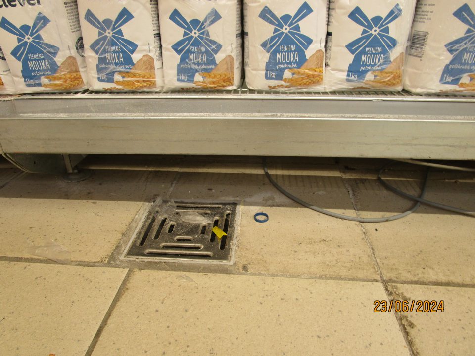 Nahromadenie nečistôt pod regálmi na predajnej ploche.