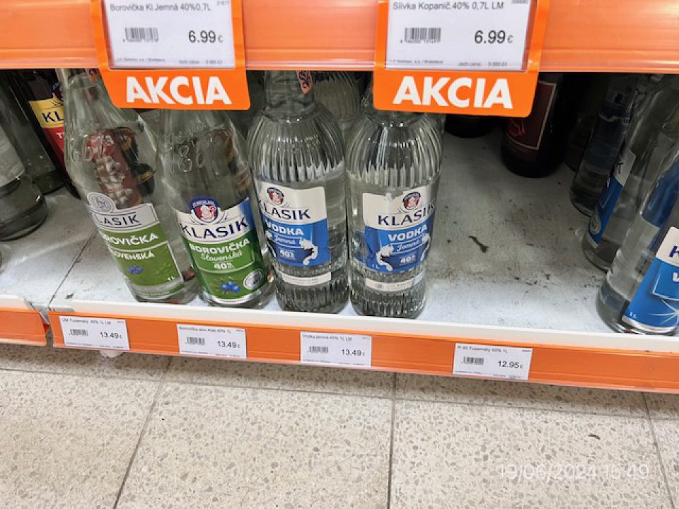 Chumáče prachu na regáli s alkoholickými nápojmi