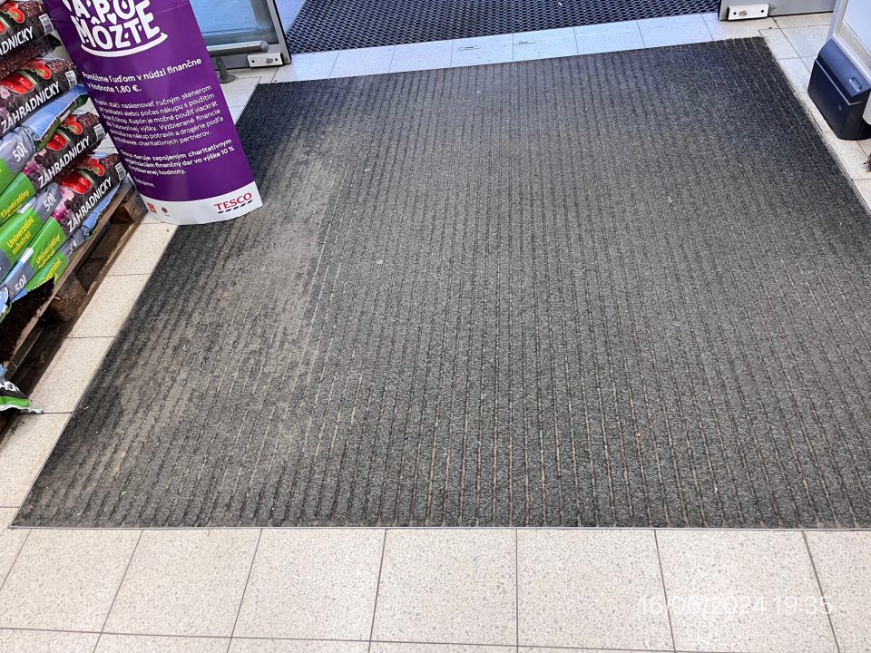 Znečistený koberec pri vstupe do prevádzkarne.